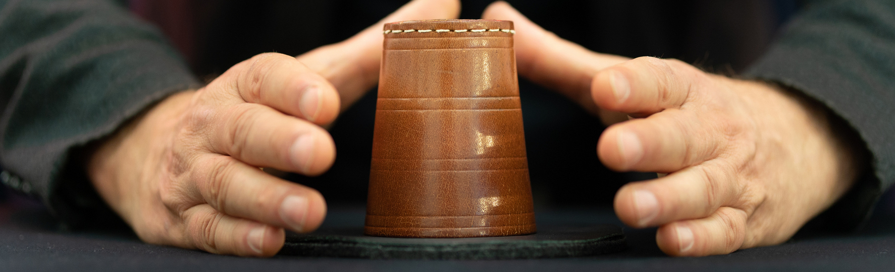 Two hands around a cup performing magic trick